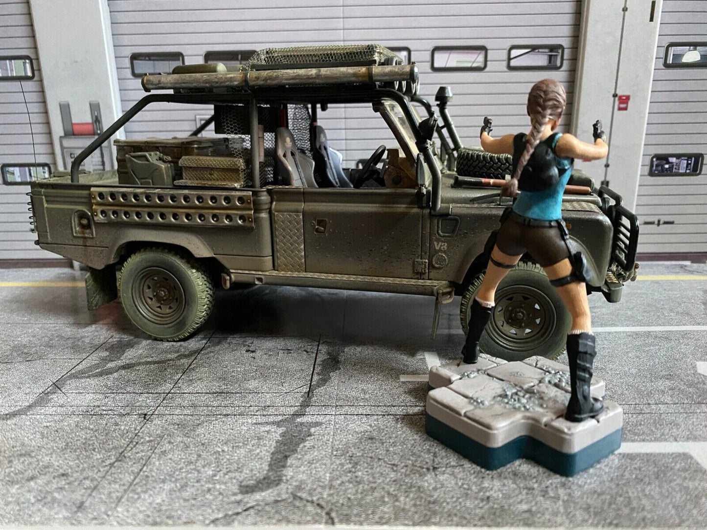 Land Rover Defender Tomb Raider weathered + Lara Croft Figur Angelina Jolie 1:18
