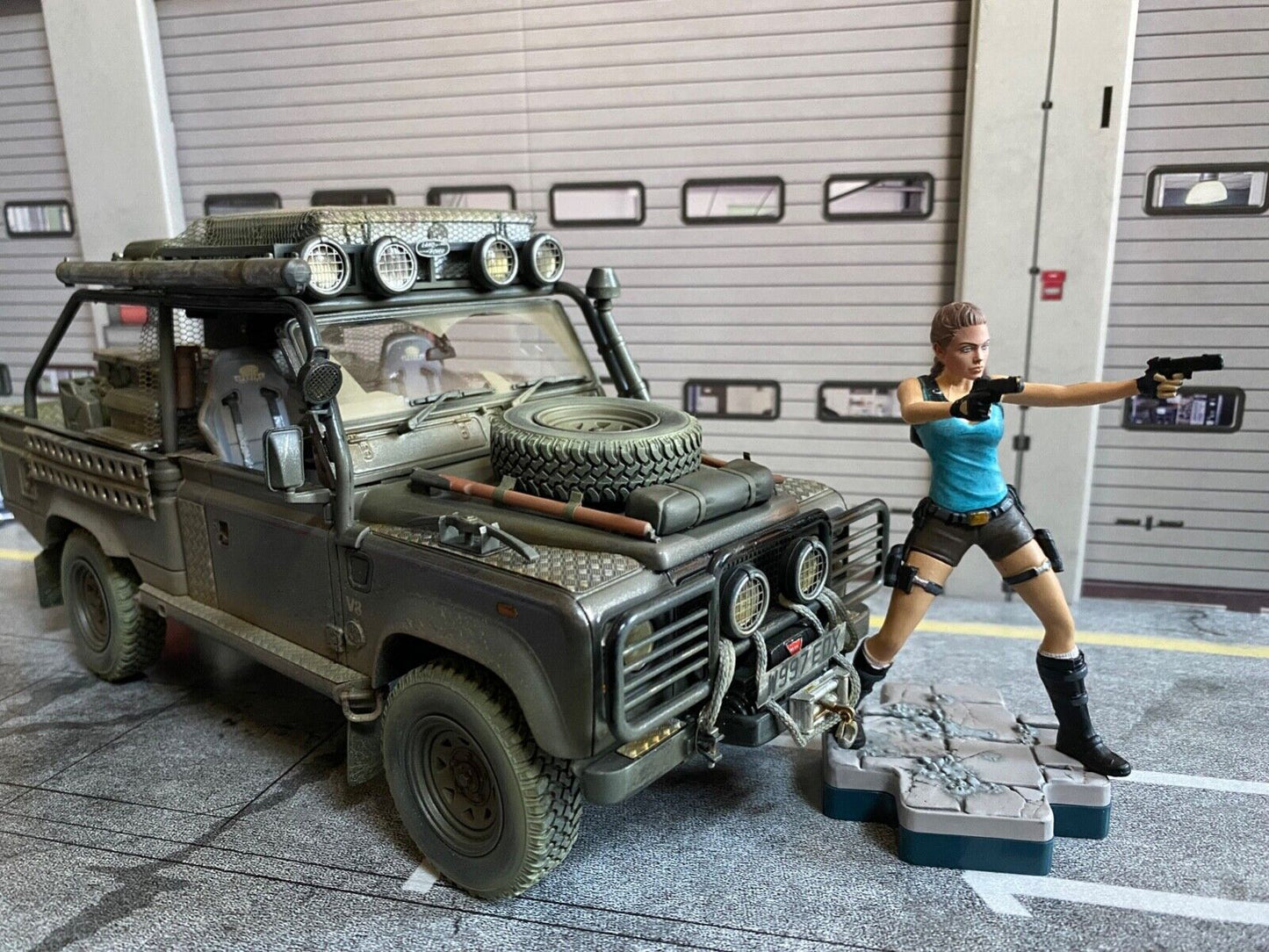 Land Rover Defender Tomb Raider weathered + Lara Croft Figur Angelina Jolie 1:18
