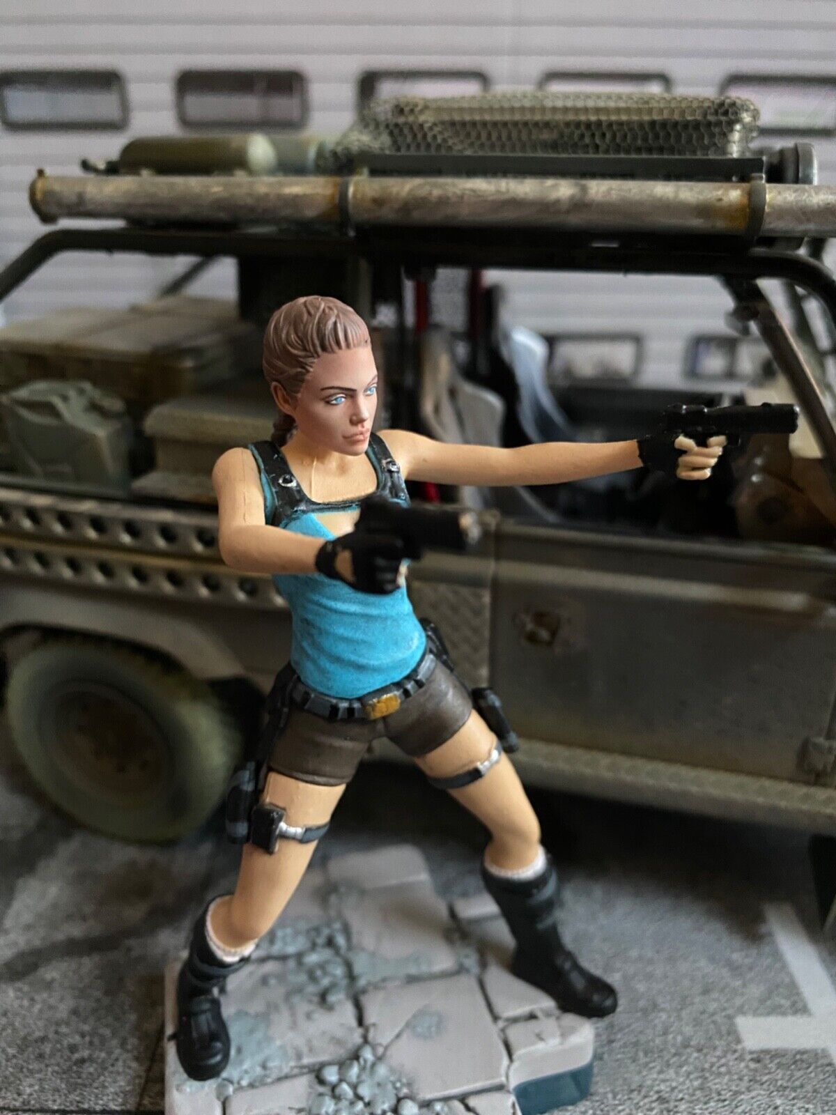 Land Rover Defender Tomb Raider weathered + Lara Croft Figur Angelina Jolie 1:18