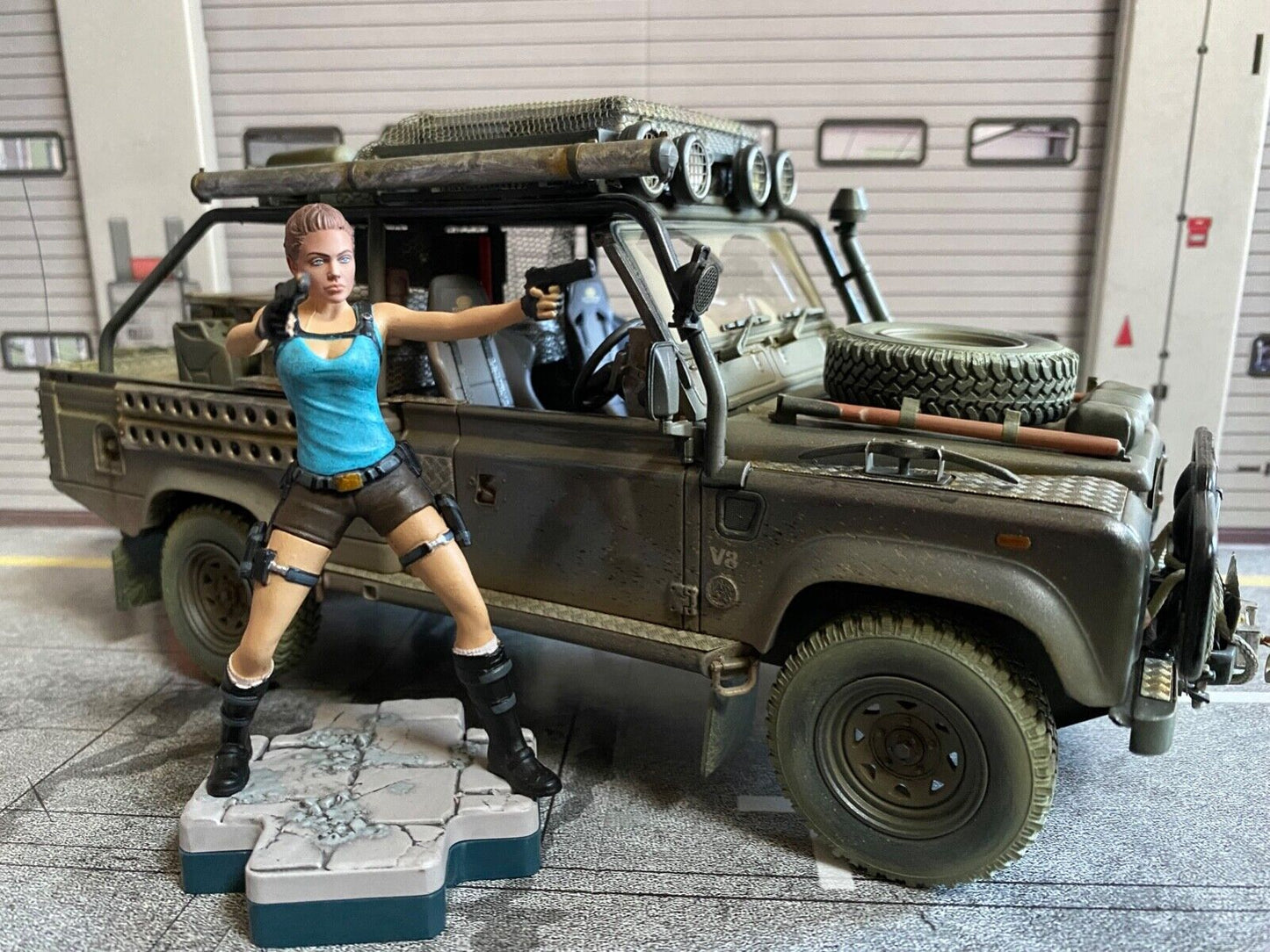 Land Rover Defender Tomb Raider weathered + Lara Croft Figur Angelina Jolie 1:18