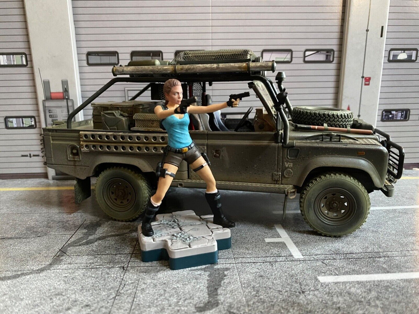 Land Rover Defender Tomb Raider weathered + Lara Croft Figur Angelina Jolie 1:18